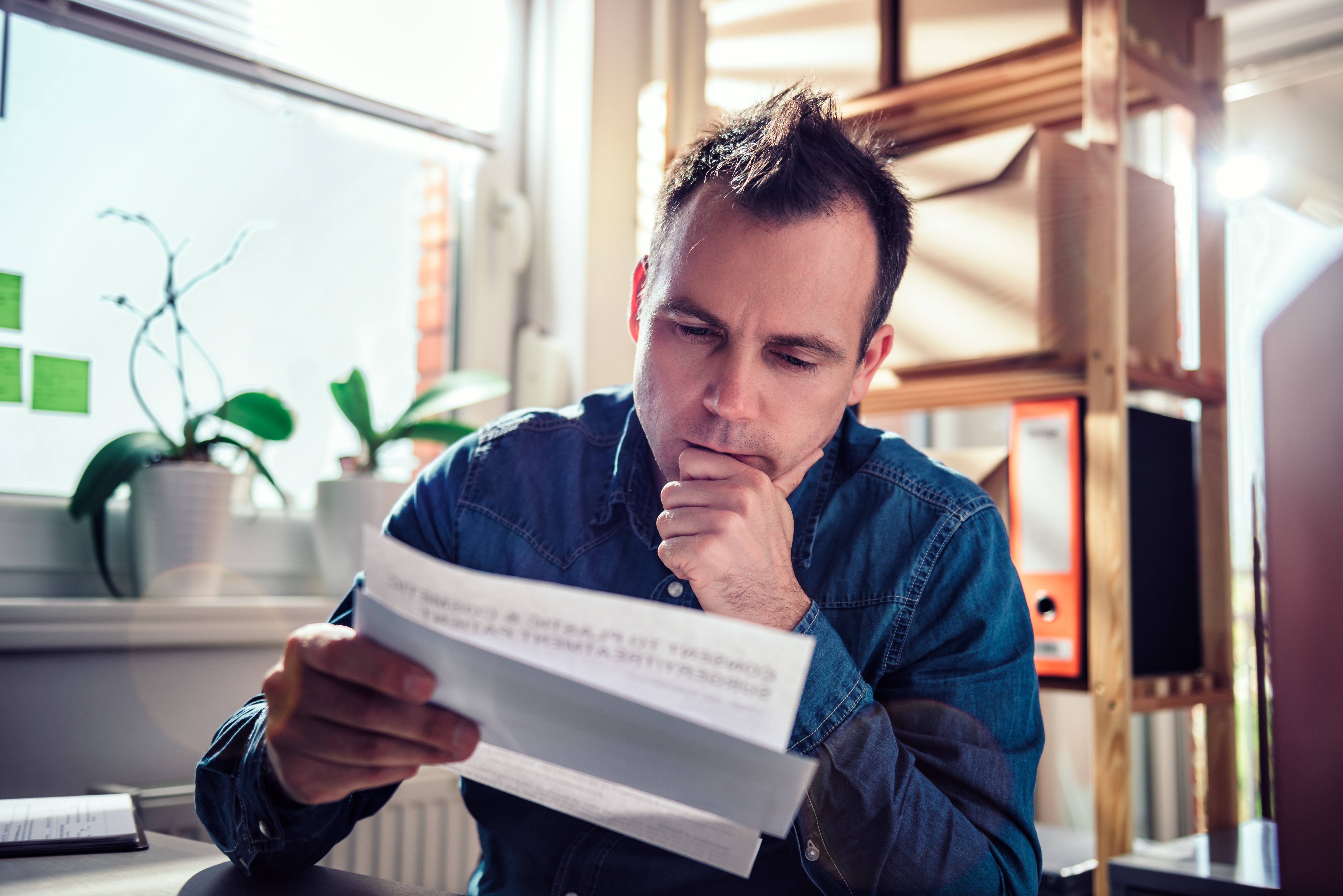 Osoba analizująca niezapłacone faktury – konsekwencje prawne i finansowe opóźnień w płatnościach